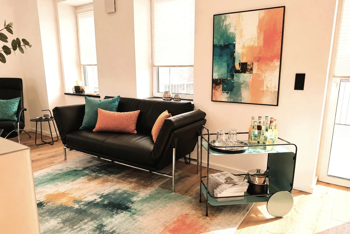Schwarzes Ledersofa mit farbigen Kissen in einem hellen Ausstellungsraum bei Möbel Zeppenfeld