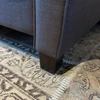 Nahaufnahme der wengefarbenen Sofafüße auf Aluplatte