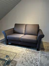 Frontansicht des Schröno Sofa Individual in braunviolettem JAB Anstoetz Stoff Vito 55 auf Teppich mit Glas-Couchtisch