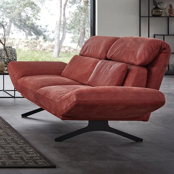 Detailansicht des Meda Sofas mit beidseitig verstellten Armlehnen – relaxte Lounge-Position und stilvoller Materialmix in moderner Architektur mit Naturblick.