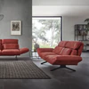 Relaxsofa Meda von Nolte Polster in Amarena-Rot mit individuell verstellbaren Armlehnen – modernes Design in offenem, lichtdurchflutetem Wohnraum mit Betonwand und großen Fensterfronten.