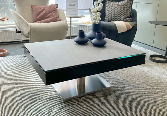 Moderner Couchtisch JANUS Janas von Ronald Schmitt mit Keramikoberfläche und dekorativen Vasen im Showroom von Zeppenfeld Wohn Evolution in Olpe