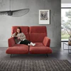 Frau entspannt auf dem verstellbaren Relaxsofa Meda – das Sofa zeigt sich mit individuell geöffnetem Sitz- und Fußteil, ideal für Lesepausen und digitale Auszeiten.