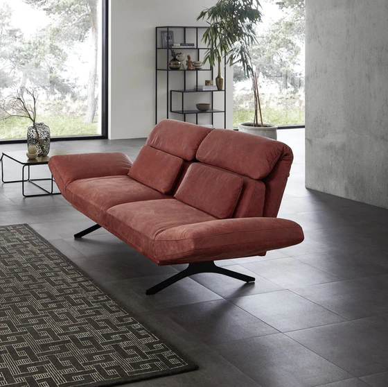 Seitenansicht des Relaxsofas Meda mit verstellbarer Rückenlehne in tiefrotem Leder – stilvolle Kombination aus Gemütlichkeit und geometrischer Eleganz.