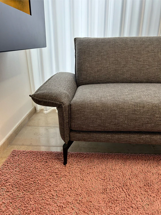 Detailansicht der linken Armlehne des Violetta Tilda Ecksofas mit elegantem Stoffbezug und Metallfüßen.