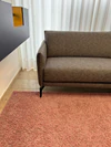 Modernes Design-Ecksofa Violetta Tilda im Möbelhaus Zeppenfeld, umgeben von Stoffmustern und stilvoller Dekoration.