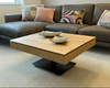 Höhenverstellbarer Couchtisch Ronald Schmitt Lignum K472 mit offener Ablage und verschiebbarer Schublade aus massiver gerillter Eiche, inszeniert in moderner Wohnzimmerumgebung.