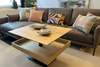 Höhenverstellbarer Couchtisch Ronald Schmitt Lignum K472 mit offener Ablage und verschiebbarer Schublade aus massiver gerillter Eiche, inszeniert in moderner Wohnzimmerumgebung.