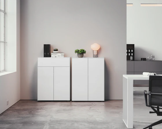 Zwei nebeneinander platzierte Kommoden Piure Nex Pur Box 2041100 und 2041300 in edlem Mattweiß, perfekt integriert in ein modernes Büroambiente mit minimalistischem Look