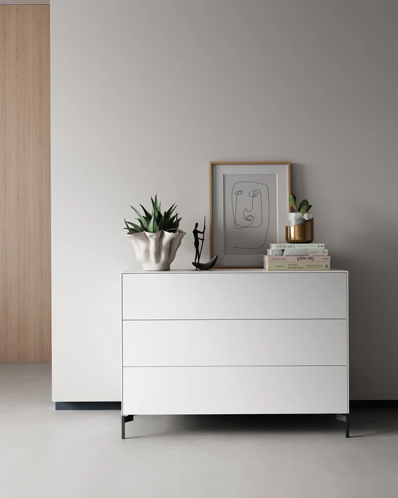 Nex Pur Box Kommode 1536776 in Weiß mit schwarzen Kufen, stilvoll dekoriert in modernem Interieur.