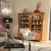 Form Exclusiv Camargue – Landhausvitrine in Kirschbaum massiv, 155×162×46 cm, Ambienteansicht mit Sessel