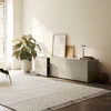 Piure Nex Pur Box 2020600 in Silk in heller Wohnumgebung – 3-türiges Sideboard unter Fenster, dekorativ inszeniert mit Kunst, Lampe und Pflanzen.