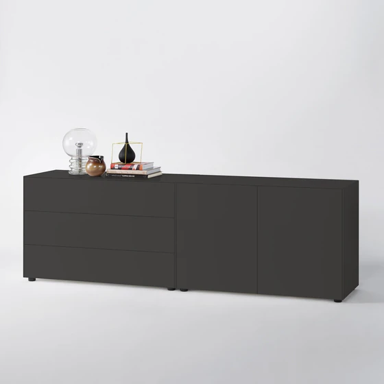 Sideboardkombination in Graphit mit drei Schubladen links und zwei Türen rechts, dekoriert mit Büchern, Vase, Kugellampe und Keramik auf weißem Hintergrund.