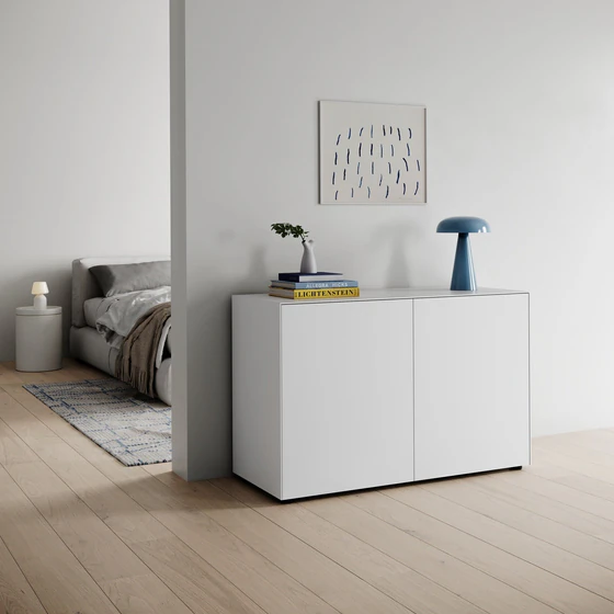 Piure Nex Pur Box 1536778 in Weiß (P01), als Kommode im Wohnbereich mit hellen Holzböden, Designlampe, Büchern und Wandbild – skandinavisch inspiriertes Interieur.