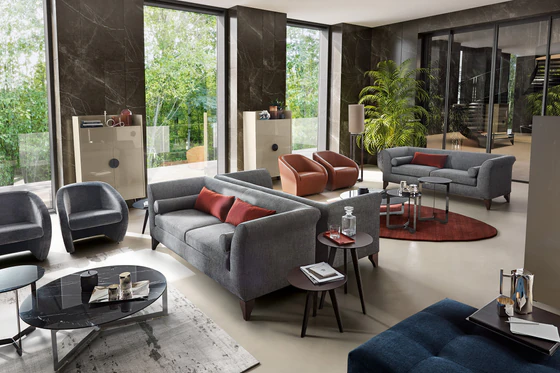 Ottomanne Sofa, im grauem Stoff mit roten Dekokissen, wohnliches Ambiente