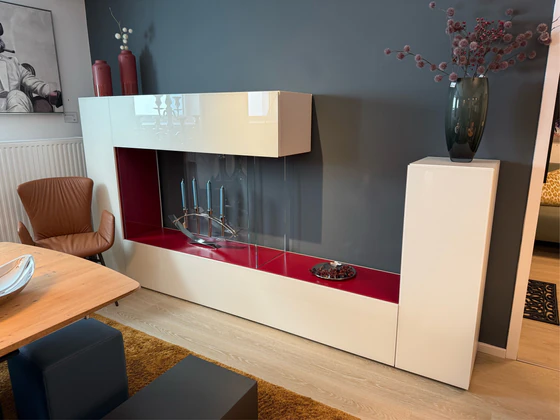 LAGO 36e8 Air Wohnwand mit geöffneter Klappe – hochwertige Innenverarbeitung und elegantes Glasdesign in Lack Weiß mit Akzent Rosso