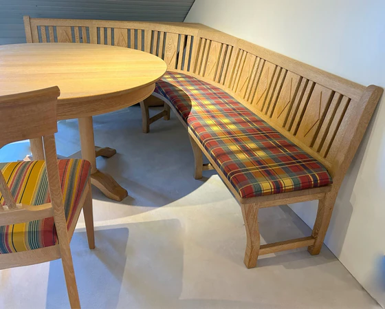 Detailaufnahme der Rundeckbank in Eiche massiv mit farbig gepolsterten Sitzflächen im Landhausstil