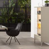 AERA Stuhl Gavi Lody mit Armlehne, Leder Dino schwarz, drehbares Rundrohrgestell schwarz, neben Sudbrock Vitrine Cubo