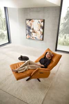 Nolte Lounger Miami in vollständiger Herz-Waage-Position, orangefarbenes Nappaleder, Frau entspannt liegend – ergonomischer Komfort in modernem Interieur.