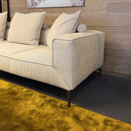 JORI Longueville Landscape Sofa Detailfoto mit Armlehne, Stoffstruktur Axil 001 und bronzemattem Fuß