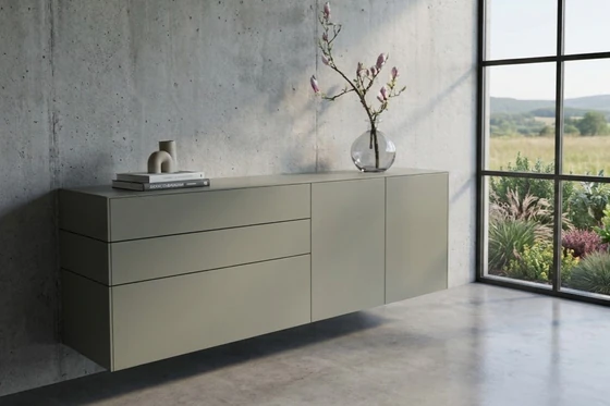 Sudbrock Cubo Hängesideboard in Salbei matt als modernes Designmöbel vor Betonwand mit klarer Linienführung